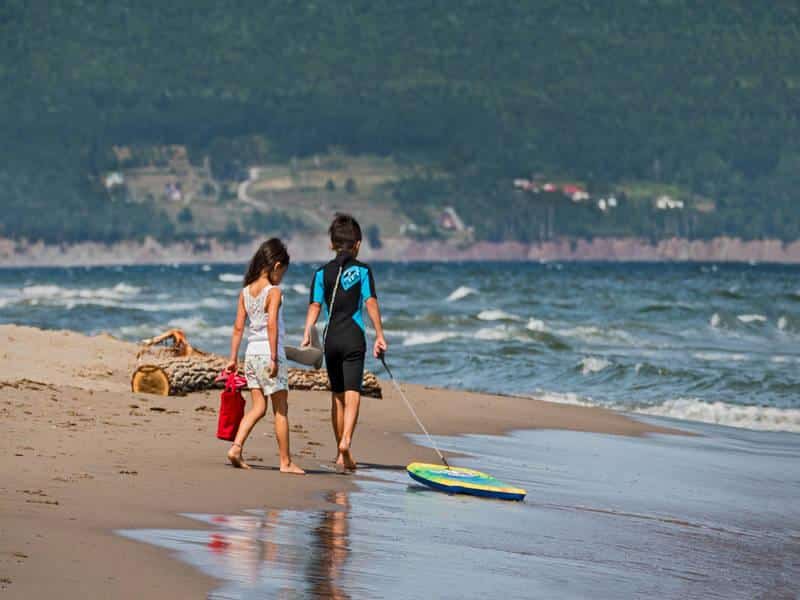 Children walking along Haldimand Beach in Gaspésie by the sea