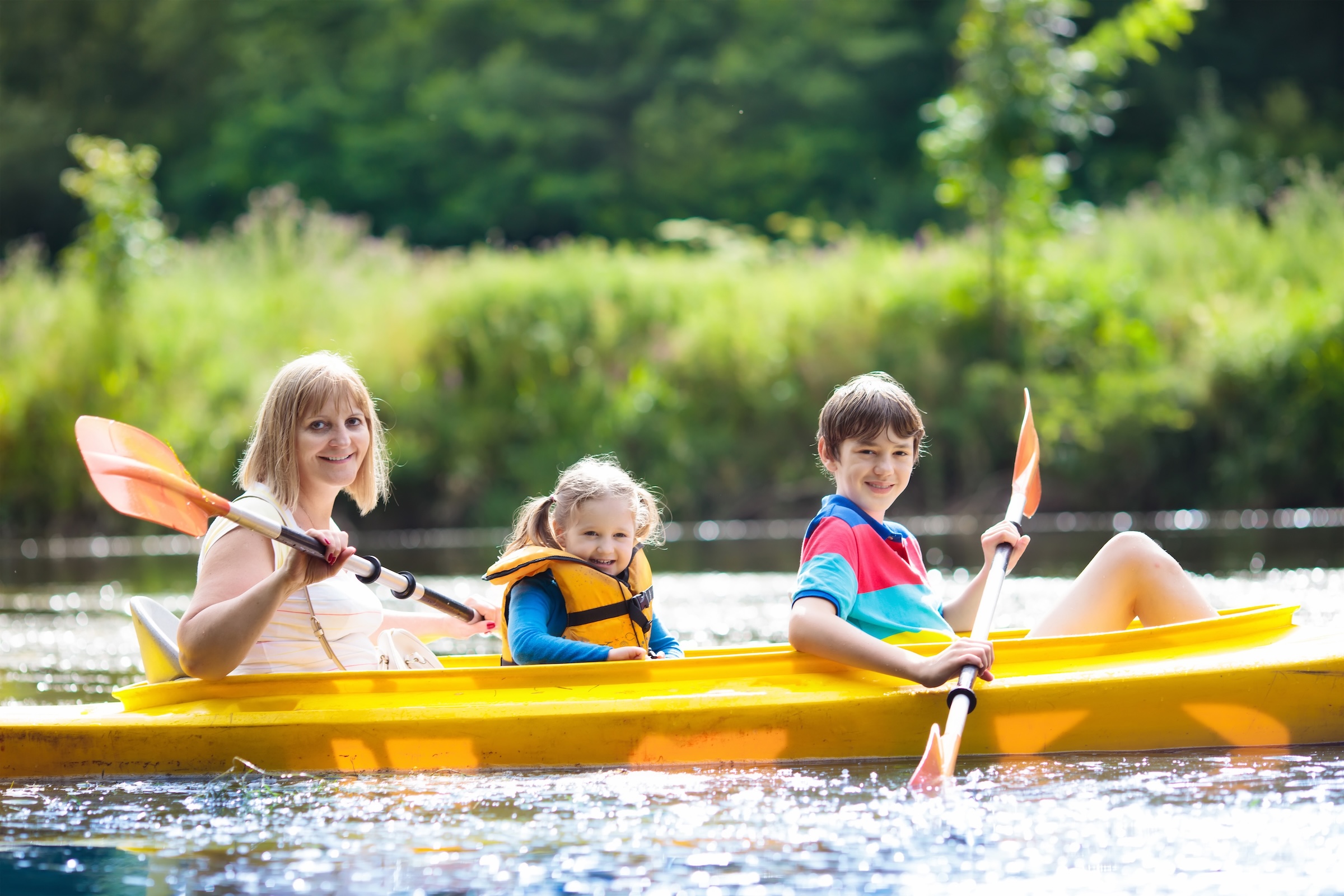Family kayaking on a lake during a cottage stay in Quebec.