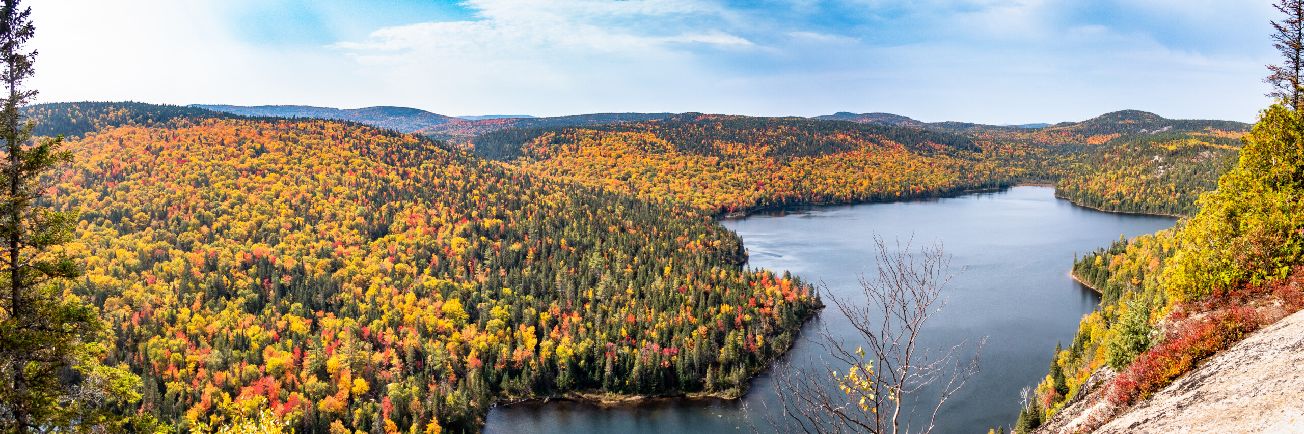Panoramic view of a lake surrounded by fall colours in Lanaudière